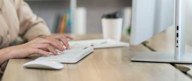 Asian% Freelance%  Woman%  Smiling%  Typing%  On%  Keyboard%  And%  Working%  On%  Laptop%  On%  Wooden%  Table%  At%  Home